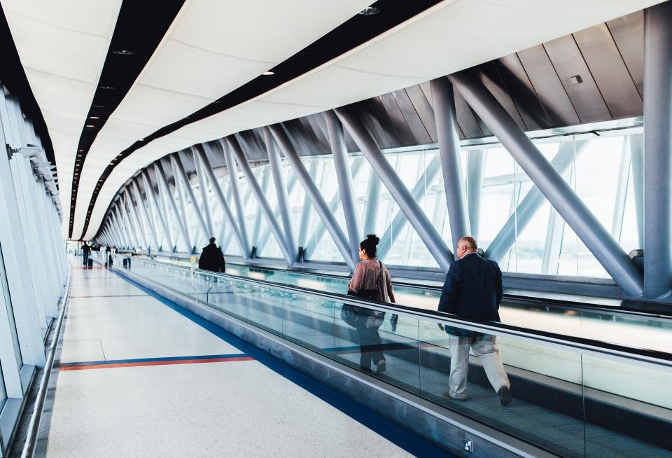 Travelers walking through an airport terminal toward their departure gate